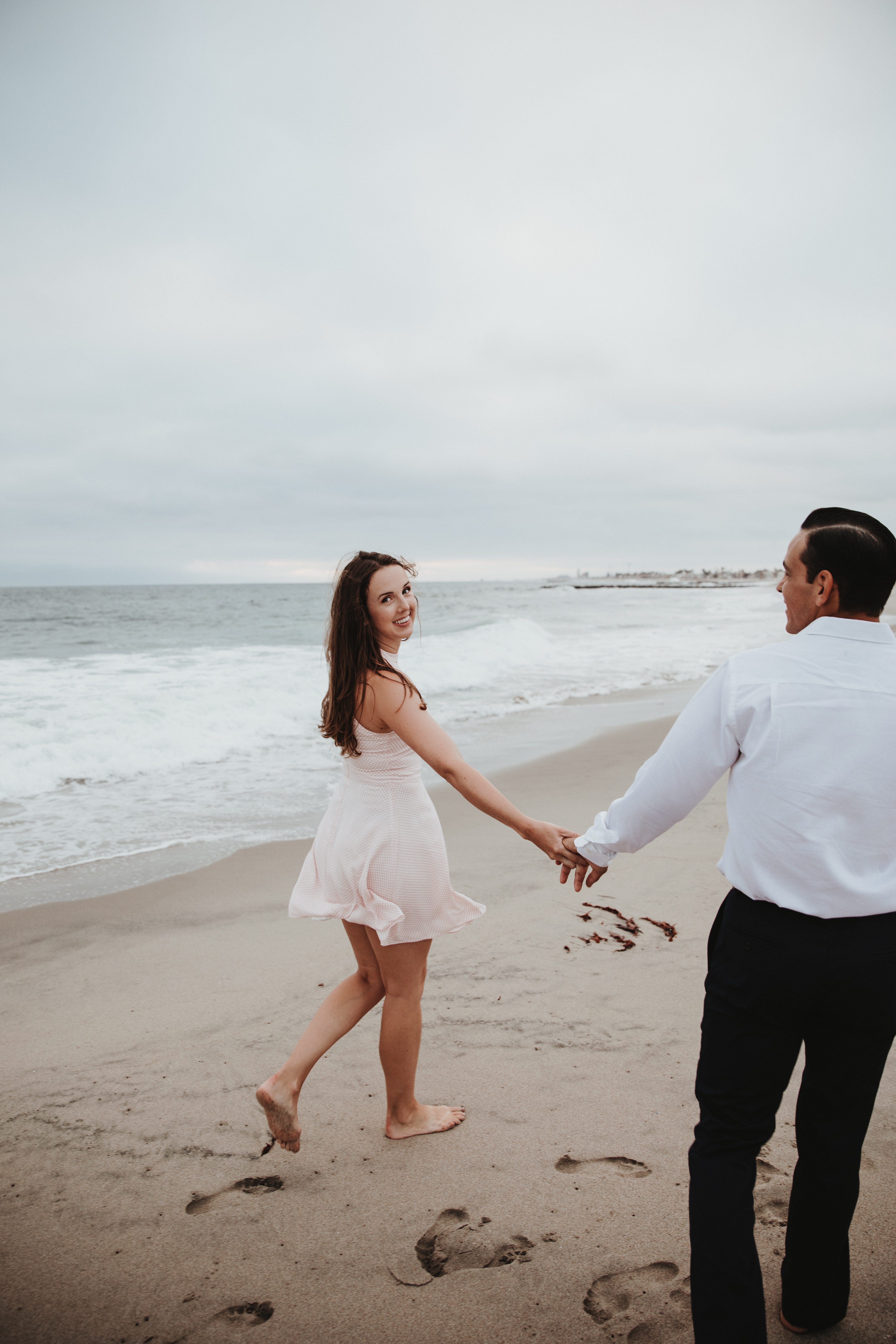 Newport Beach engagement couple photography smiling walking beach sunset love happy